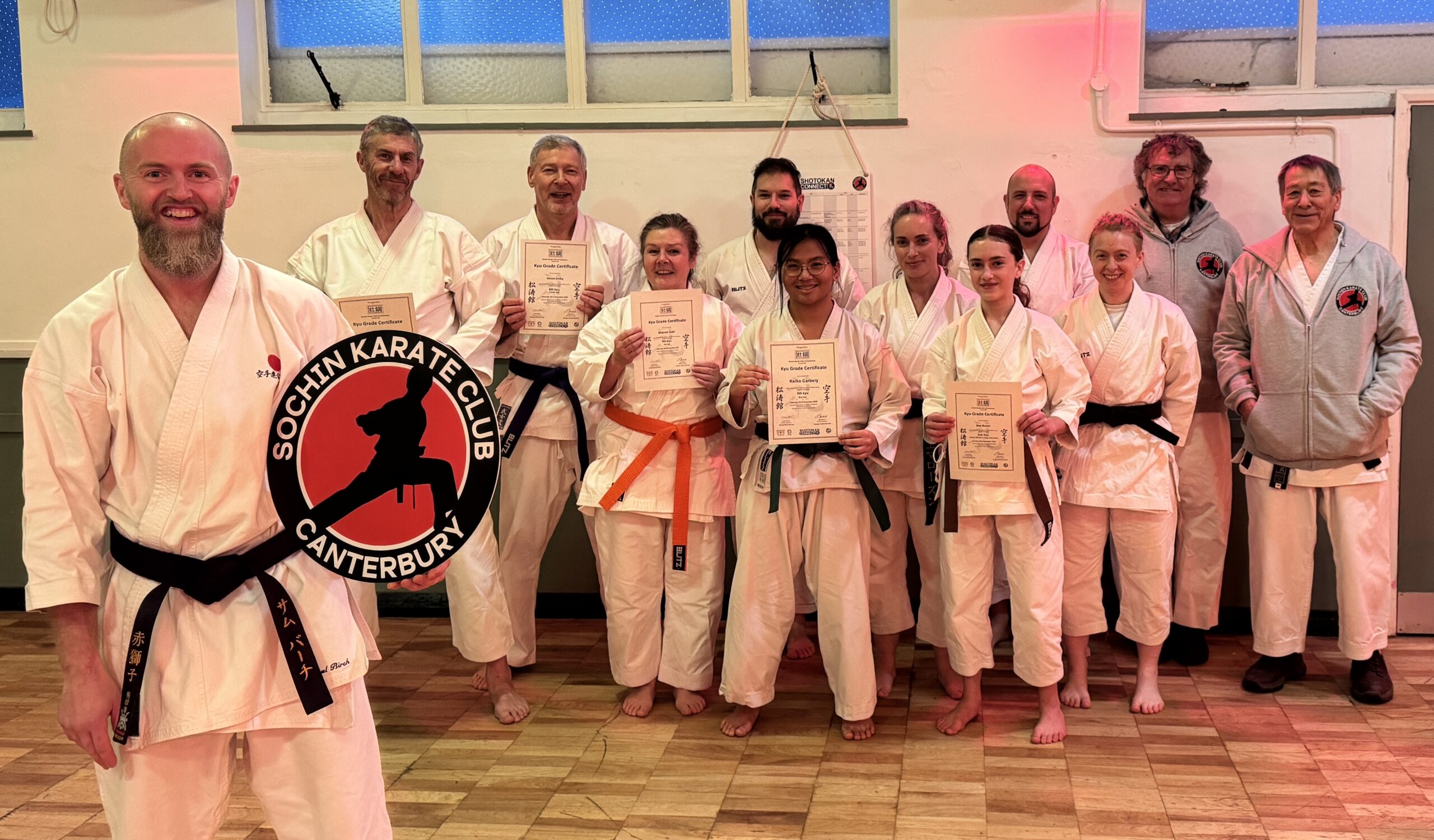 Sensei Sam holding club logo with club members