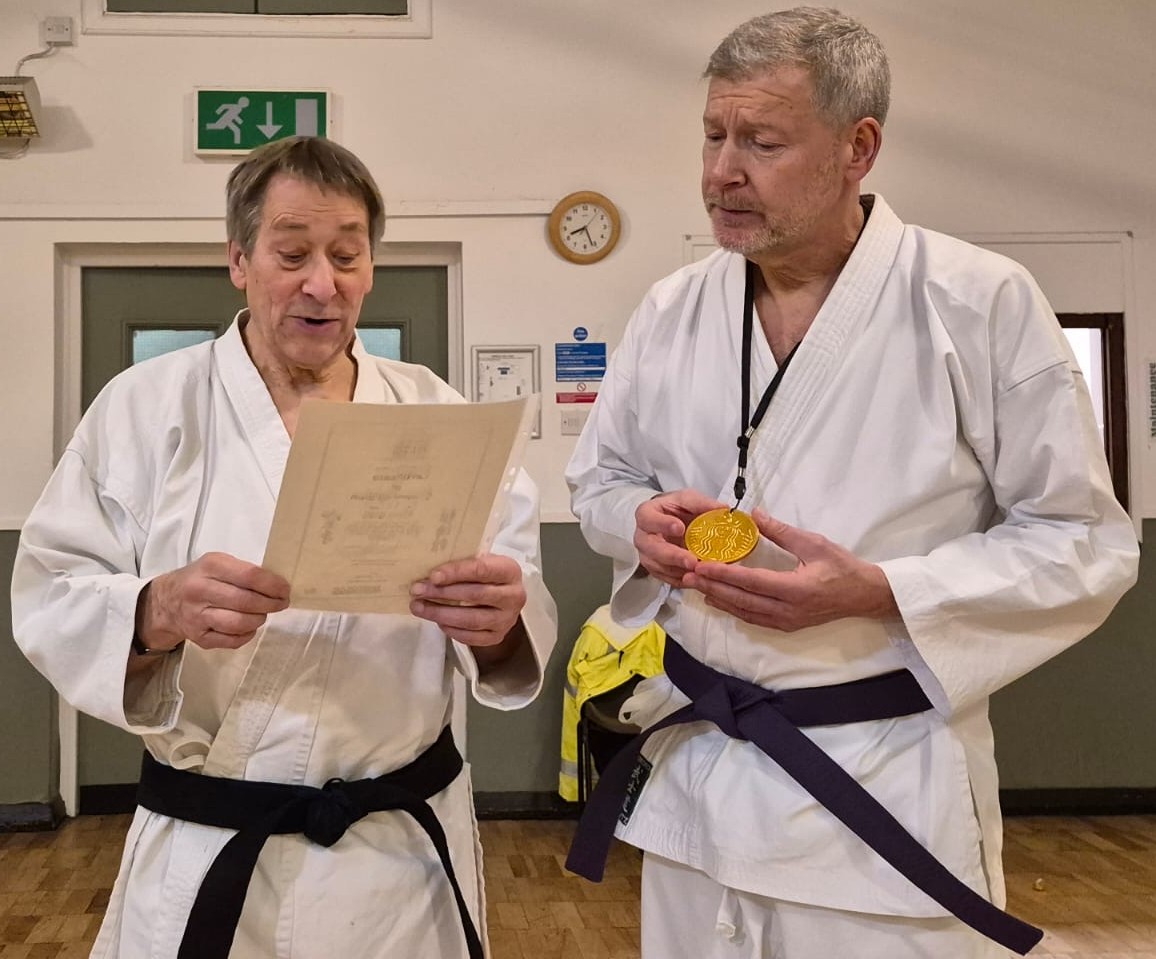 Georges presents certificate and medal to Simon